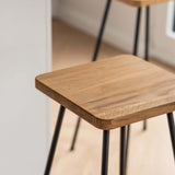 Der Barhocker Barni mit hochwertigem Massiv-Holz als Sitzfläche und einem schwarzem Metallgestell | Metallbude